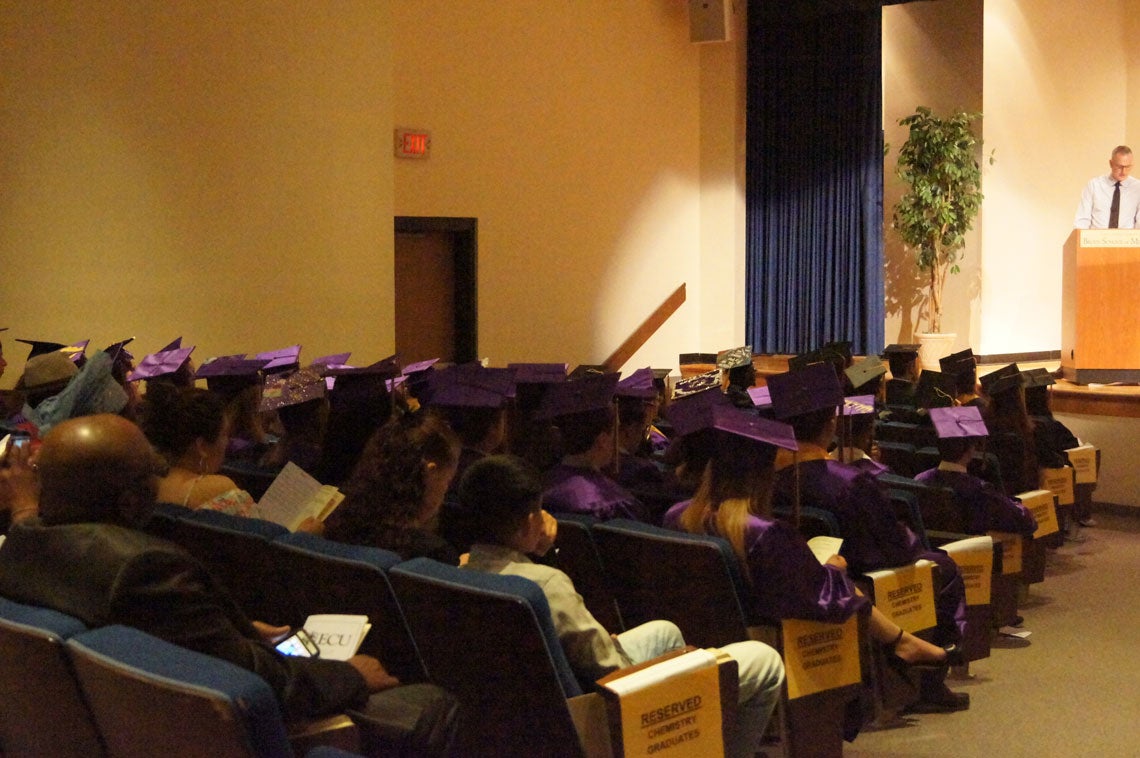 Graduates sitting in an auditorium.