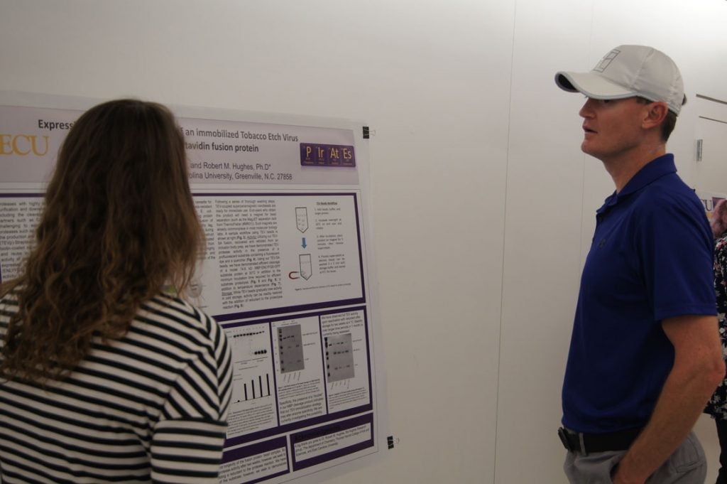 Students presenting their posters in a hallway.