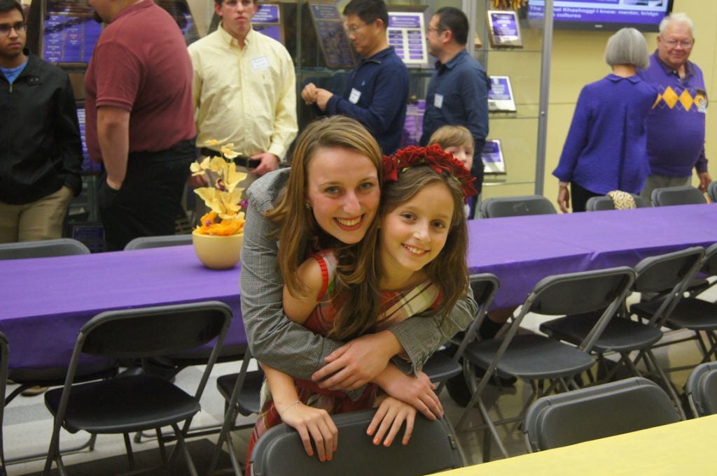 Woman hugging a young girl and smiling.