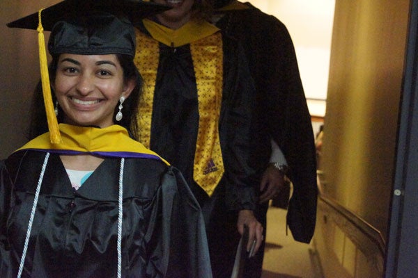 Female graduate student in graduation regalia.